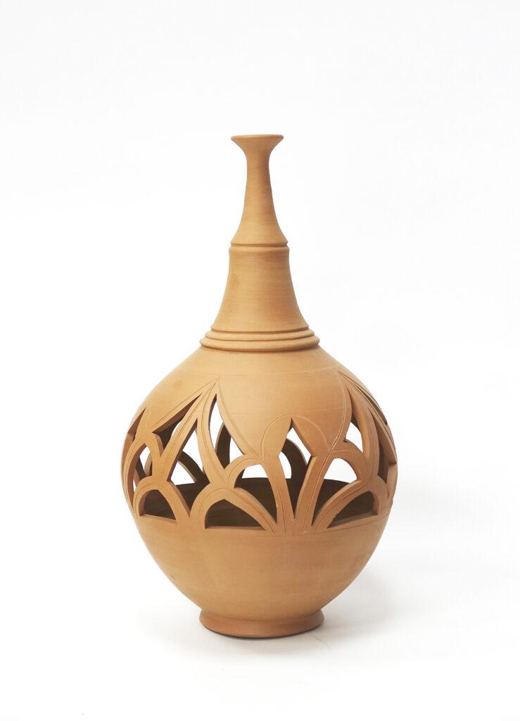 Imagen de Jarrón decorativo de vaso ancho y boca estrecha realizado en arcilla y acabado natural con calado inspirado en formas arabescas